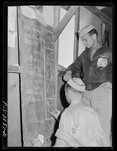 Two lieutenants of pursuit squadron map out the formations in which they will lead their flights. Lake Muroc, California