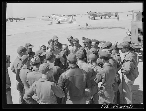 A lieutenant of a pursuit squadron explains an assignment to some of the "Flying Sergeants" at Lake Muroc, California