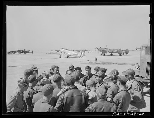 Untitled photo, possibly related to: A lieutenant of a pursuit squadron explains an assignment to some of the "Flying Sergeants" at Lake Muroc, California
