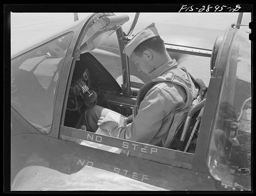 Pilot checks his records upon completion of flight at Lake Muroc, California