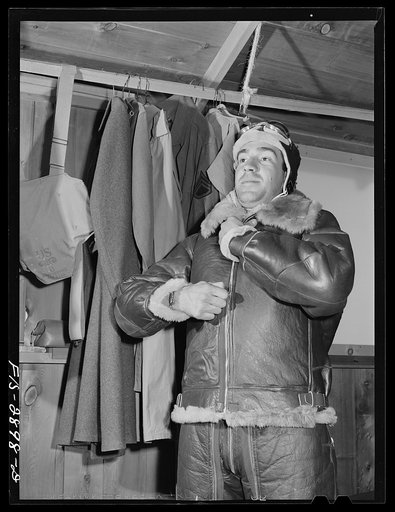 "Flying Sergeant" dressing in his high altitude cold weather flying suit. Lake Muroc, California