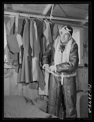"Flying Sergeant" dressing in his high altitude cold weather flying suit. Lake Muroc, California
