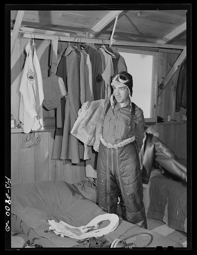 "Flying Sergeant" dressing in his high altitude cold weather flying suit. Lake Muroc, California
