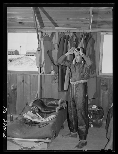 "Flying Sergeant" dressing in his high altitude cold weather flying suit. Lake Muroc, California