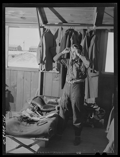 Untitled photo, possibly related to: "Flying Sergeant" dressing in his high altitude cold weather flying suit. Lake Muroc, California