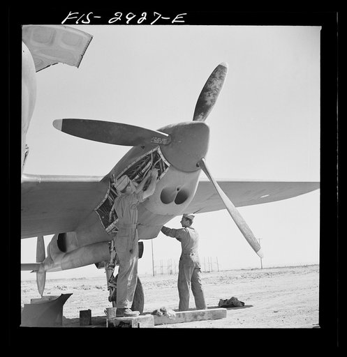 Untitled photo, possibly related to: Working in the motor of an interceptor plane. Lake Muroc, California