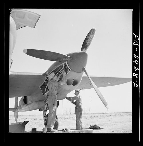 Working in the motor of an interceptor plane. Lake Muroc, California