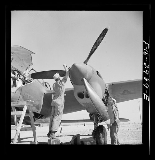Replacing propeller hub of interceptor plane. Lake Muroc, California