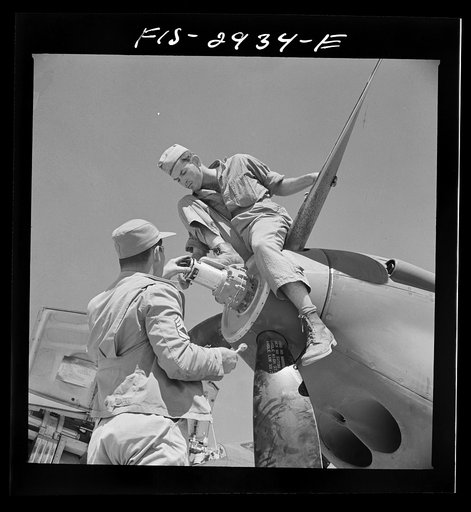 Working on the nose of one engine of an interceptor plane. Lake Muroc, California