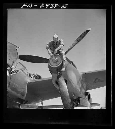 Working on the nose of one engine of an interceptor plane. Lake Muroc, California