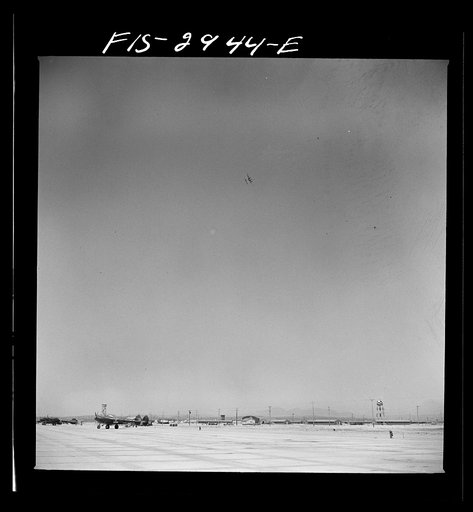 Untitled photo, possibly related to: "Buzzing" the field. Member of interceptor squadron swoops low over parked airplanes to simulate a strafing attack on an airport. Lake Muroc, California