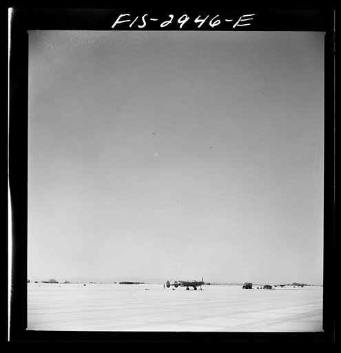 Untitled photo, possibly related to: "Buzzing" the field. Member of interceptor squadron swoops low over parked airplanes to stimulate a strafing attack on an airport. Lake Muroc, California