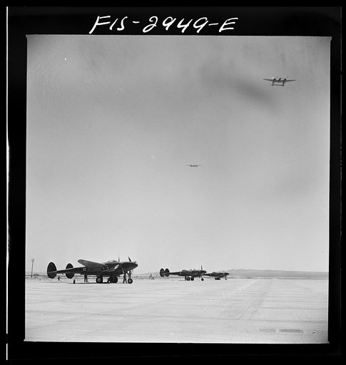Untitled photo, possibly related to: "Buzzing" the field. Member of interceptor squadron swoops low over parked airplanes to stimulate a strafing attack on an airport. Lake Muroc, California