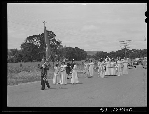 Banner of the I.D.E.S.I. society goes before the Queen in the parade of the Holy Ghost Festival of the Portuguese-Americans at Novato, California