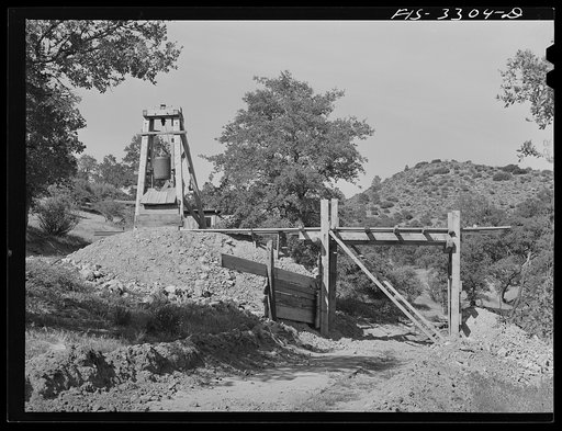 Kern County, California. Tungsten Chief Mine. One of the shafts. Ore is loaded into hand cars and pushed out onto an overhead trestle where it is dumped into trucks for transport to the mill