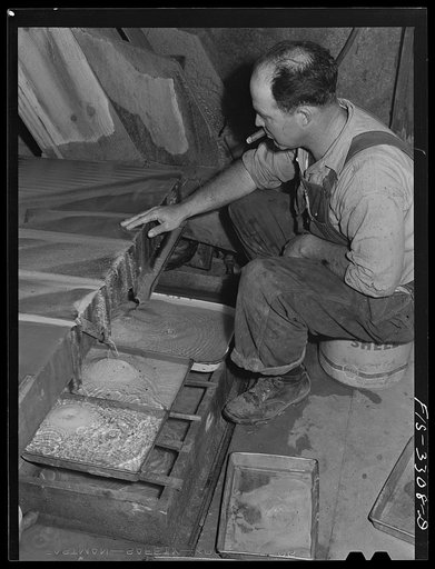 Kern County, California. Mill of the Tungsten Chief Mine. Pulverized tungsten ore is mixed with water and then run over a vibratory table where the ore is further concentrated; in this picture the final concentrates appear in the two pans in the lower left hand corner