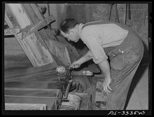 Kern County, California. Mill of the Tungsten Chief Mine. When ore concentrate collects at the edge of the vibrator table, the operator adds water to wash off the thick accumulated concentrate