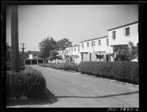 Untitled photo, possibly related to: Greenbelt, Maryland. Federal housing project. A row of flat-roofed houses. Front yards communicate with the roads by paths