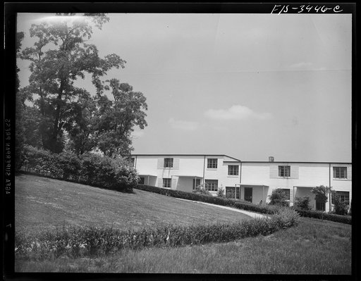 Greenbelt, Maryland. Federal housing project. A row of flat-roofed houses. Front yards communicate with the roads by paths