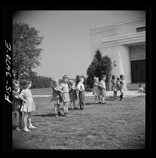 Untitled photo, possibly related to: Greenbelt, Maryland. Federal housing project. Kindergarten children practice their May Day dances on the grass in front of the school