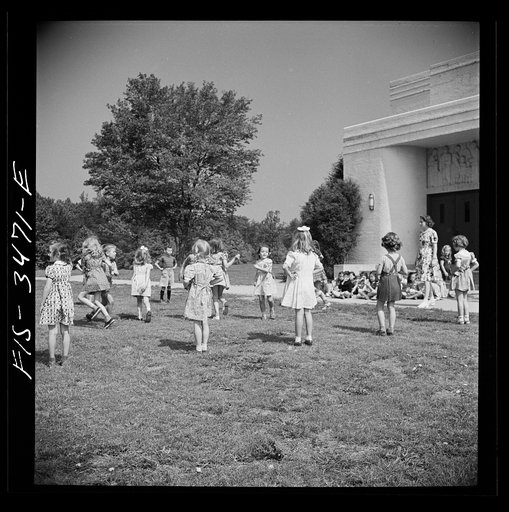 Untitled photo, possibly related to: Greenbelt, Maryland. Federal housing project. Kindergarten children practice their May Day dances on the grass in front of the school