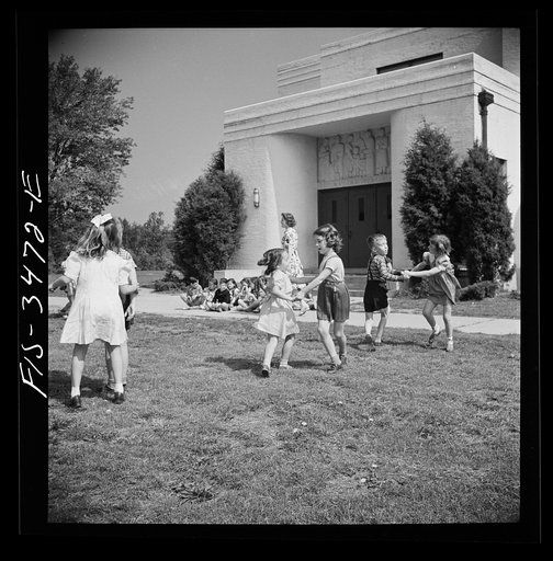 Untitled photo, possibly related to: Greenbelt, Maryland. Federal housing project. Kindergarten children practice their May Day dances on the grass in front of the school