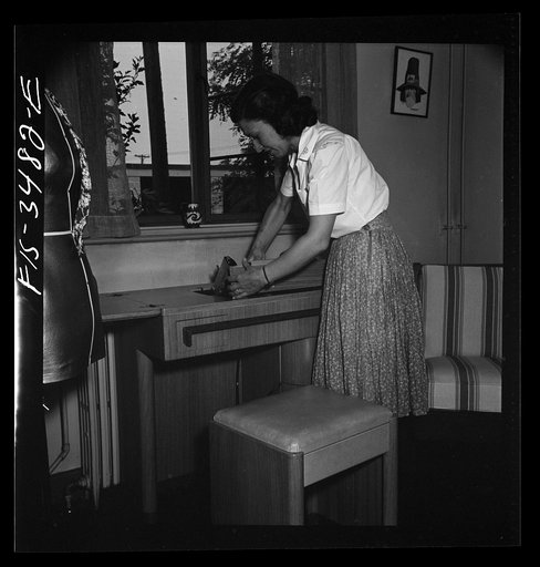 Untitled photo, possibly related to: Greenbelt, Maryland. Federal housing project. Mrs. Leslie Atkins keeps scraps and supplies in the seat of her sewing machine stool
