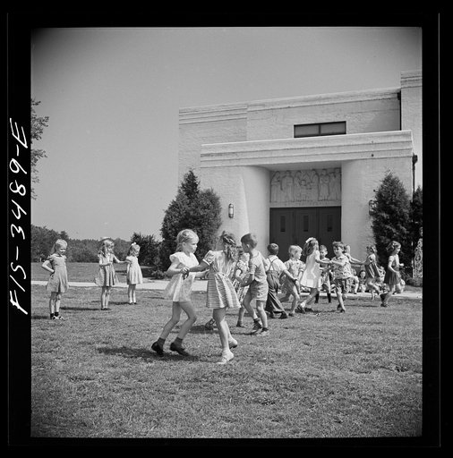 Untitled photo, possibly related to: Greenbelt, Maryland. Federal housing project. Kindergarten children practice their May Day dances on the grass in front of the school