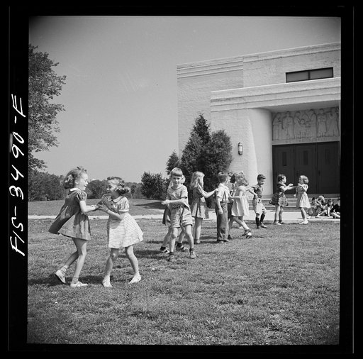 Untitled photo, possibly related to: Greenbelt, Maryland. Federal housing project. Kindergarten children practice their May Day dances on the grass in front of the school
