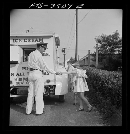 Greenbelt, Maryland. Federal housing project. Ann Atkins buying ice cream from the Good Humor man, a daily visitor