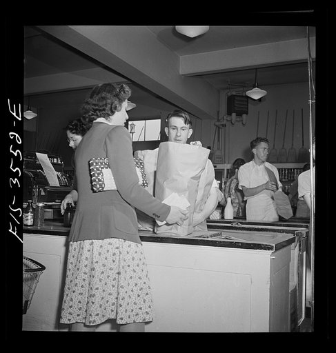 Greenbelt, Maryland. Federal housing project. Paying for purchases at the checking out gate of the cooperative grocery store