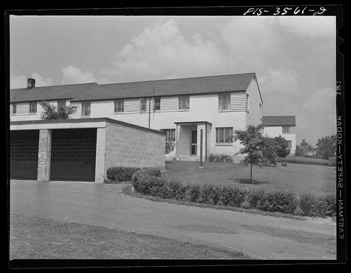 Greenbelt, Maryland. Rows of gable-roofed houses showing open garages in back