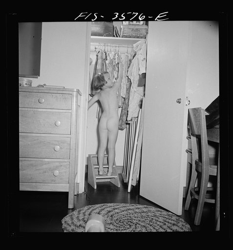 Greenbelt, Maryland. Ann Atkins taking a dress out of her closet by climbing on the ladder built especially for her. Ann is six, and moved to Greenbelt when she was a year old