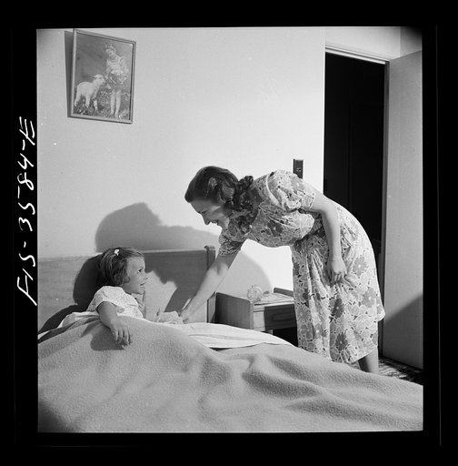 Greenbelt, Maryland. Mrs. Atkins putting Ann to bed in her room. Pierce has a room of his own