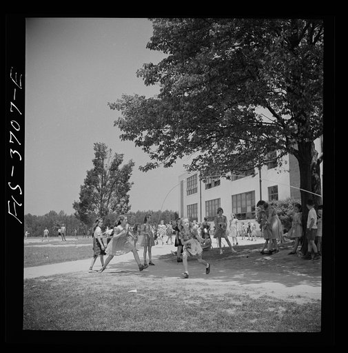 Greenbelt, Maryland. Children playing under trees during a school recreation period