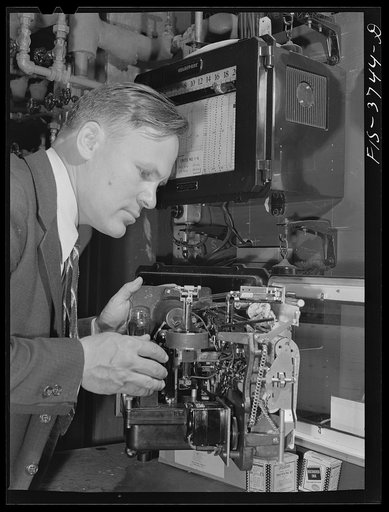 Untitled photo, possibly related to: G.T. Hemmeter, chief of the mechanical engineering section of the engineering and development division, sets one of the automatic recording thermometers used on tunnel dryer which he designed for dehydrating vegetables. Regional agricultural research laboratory, 