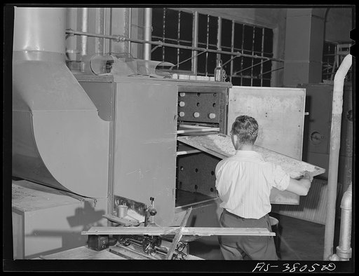 Putting ray of potatoes into small cabinet dryer for dehydration. Regional agricultural research laboratory, Albany, California