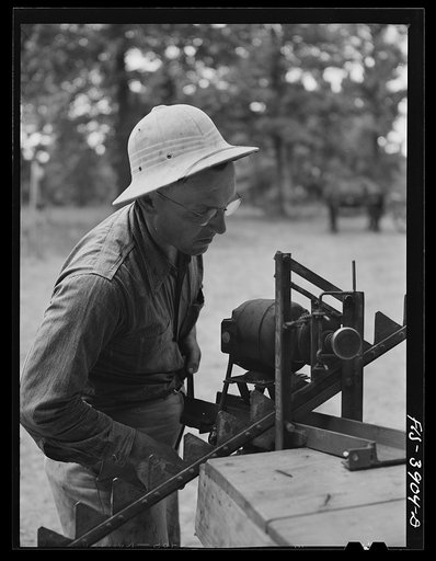 Lauderdale County, Alabama. Tennessee Valley Authority (TVA). Julien H. Case sharpening the teeth of a hay rake with a portable electric motor
