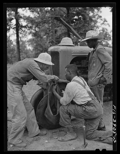 Lauderdale County, Alabama. Tennessee Valley Authority (TVA). Julien H. Case and his hired hand fix flat tractor tire