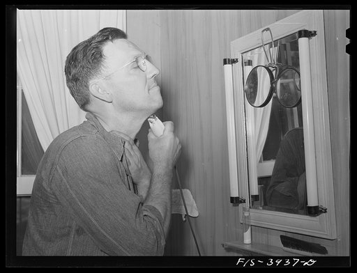Lauderdale County, Alabama. Tennessee Valley Authority (TVA). Julien H. Case uses an electric shaver and fluorescent light in the bathroom of his farm home
