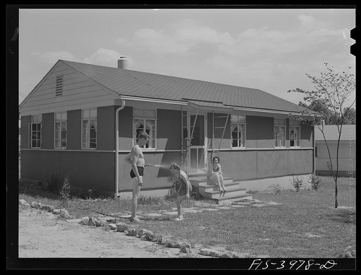 Untitled photo, possibly related to: Sheffield, Alabama (Tennessee Valley Authority (TVA)). Kenneth Hall gives daughter Peggy a shower with garden hose in front of their TVA defense home