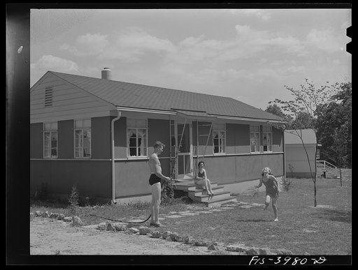 Sheffield, Alabama (Tennessee Valley Authority (TVA)). Kenneth Hall gives daughter Peggy a shower with garden hose in front of their TVA defense home