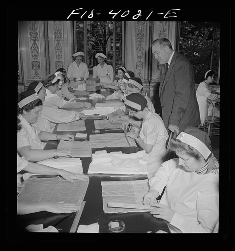 Washington, D.C. Mr. Lund, who is head of the District Red Cross, dropped in at the District chapter house, where a Norwegian unit of the Red Cross was wrapping bandages
