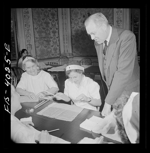 Untitled photo, possibly related to: Washington D.C. Mr. Lund, who is the head of the District Red Cross, dropped in at the District chapter house where a Norwegian unit of the Red Cross was wrapping bandages