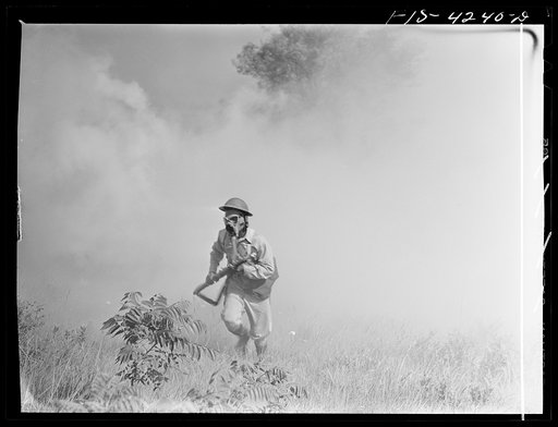 Fort Riley, Kansas. A soldier of a rifle platoon of a cavalry unit advancing through a smokescreen during a sham battle