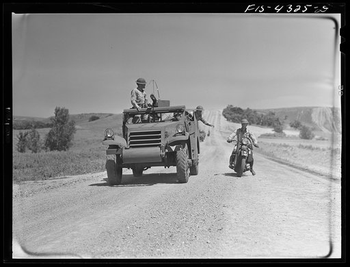 Untitled photo, possibly related to: Fort Riley, Kansas. Delivering a message to a moving scout car during a field problem
