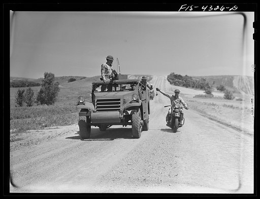 Untitled photo, possibly related to: Fort Riley, Kansas. Delivering a message to a moving scout car during a field problem