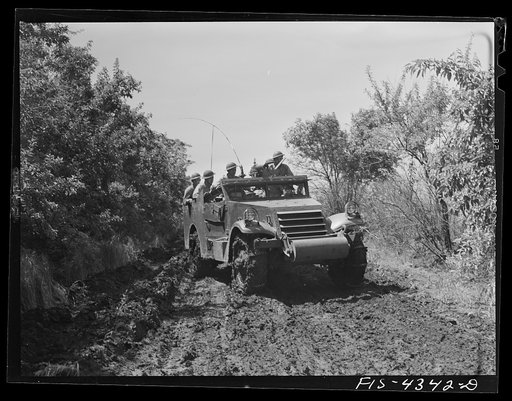 Fort Riley, Kansas. Scout car maneuvering along a muddy road during a sham battle