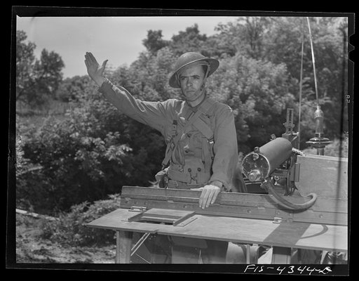Untitled photo, possibly related to: Fort Riley, Kansas. Signaling "halt" during a sham battle of a reconnaissance unit