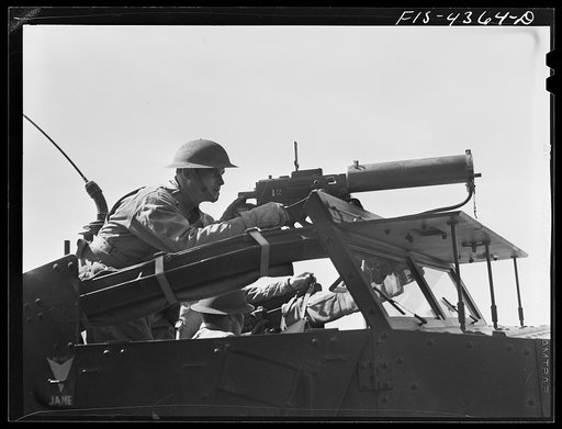 Untitled photo, possibly related to: Fort Riley, Kansas. Scout car machine gunner in action during a sham battle